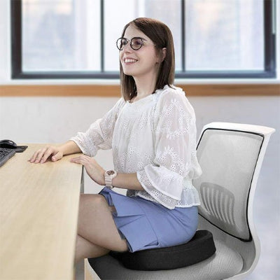 Coussin d assise ergonomique | CoccyxZen™ femme souriante assise a son bureau