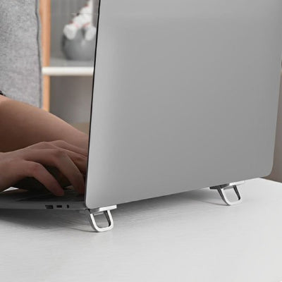 Support bureau pour ordinateur portable pliable en aluminium utilisé avec un ordinateur portable sur un bureau. Son design compact et ergonomique surélève l'écran pour favoriser une meilleure posture, réduire les douleurs au cou et au dos et améliorer la ventilation de l'appareil. Léger, discret et facile à transporter, il est idéal pour le télétravail, le bureau, les études et les déplacements.