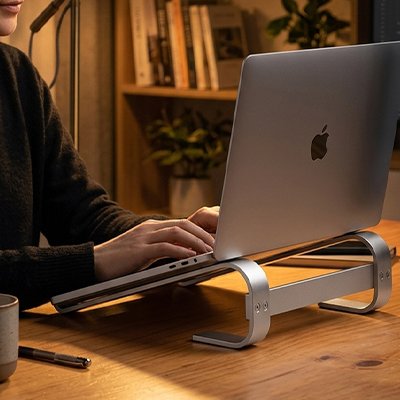 Ordinateur portable installé sur un support pour ordinateur portable ergonomique en aluminium sur un bureau en bois