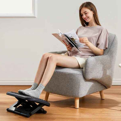 jeunne femme assise sur fauteuil avec les pieds poser sur le repose pied bureau