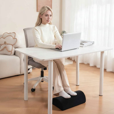 repose pied bureau avec femme assise a son bureau 