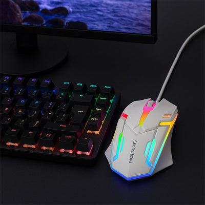 Souris ambidextre SKYLiON blanche éclairée près d’un clavier sur un bureau noir