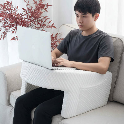 homme travaillant sur son portable posé sur support ordinateur portable pour le lit en Mousse Mémoire blanc sur son canapé