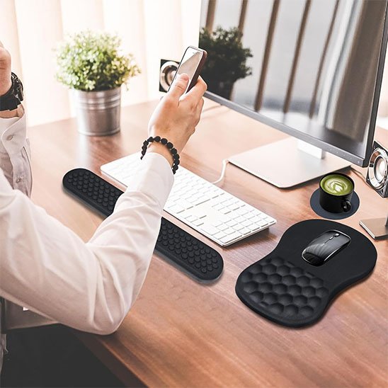 Tapis de souris​ ergonomique sur bureau avec un homme cellulaire dans main